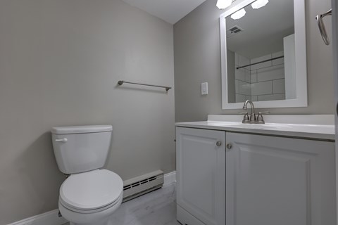 A white toilet sits next to a white sink in a bathroom.