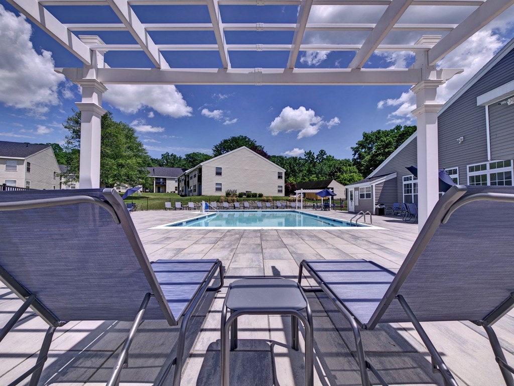 the pool is under a large patio with chairs