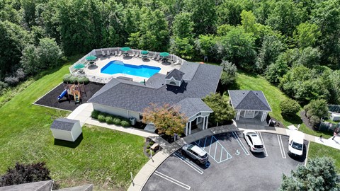 A large house with a pool and a parking lot.