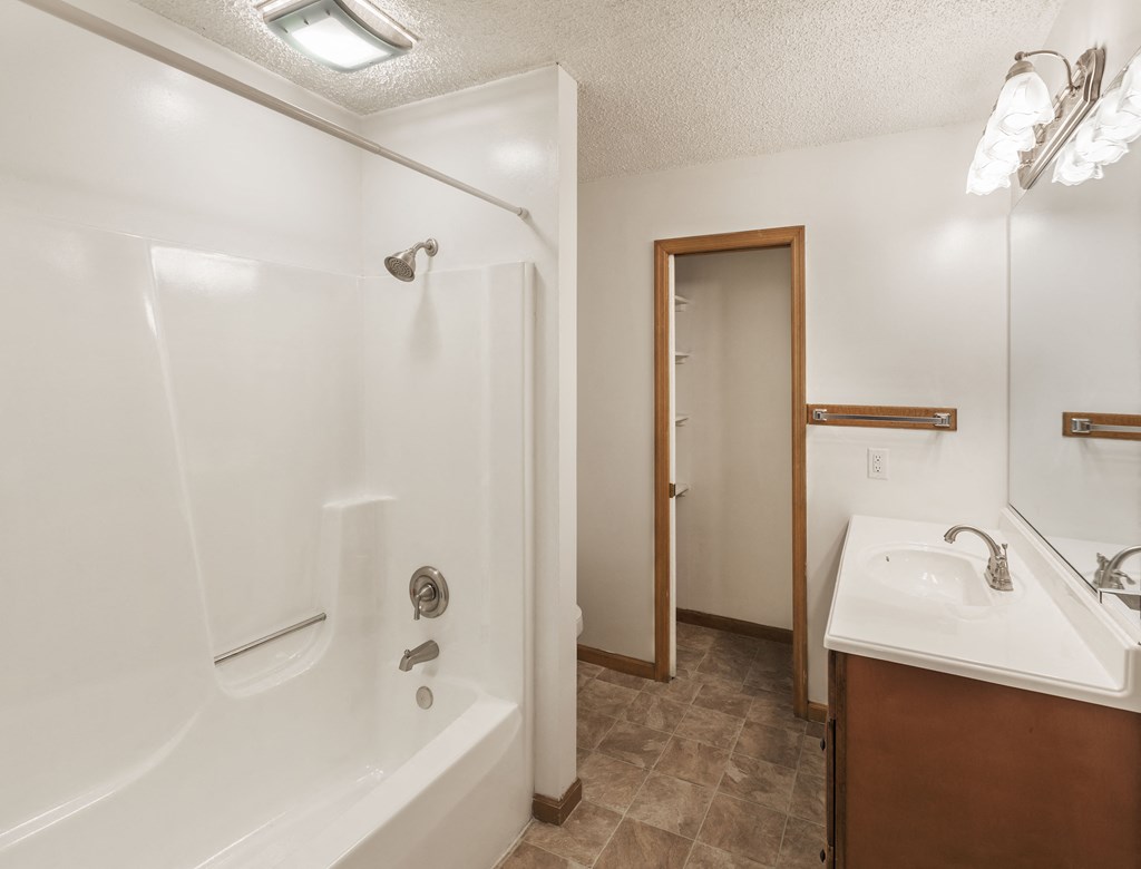 a bathroom with a shower and a sink and a mirror