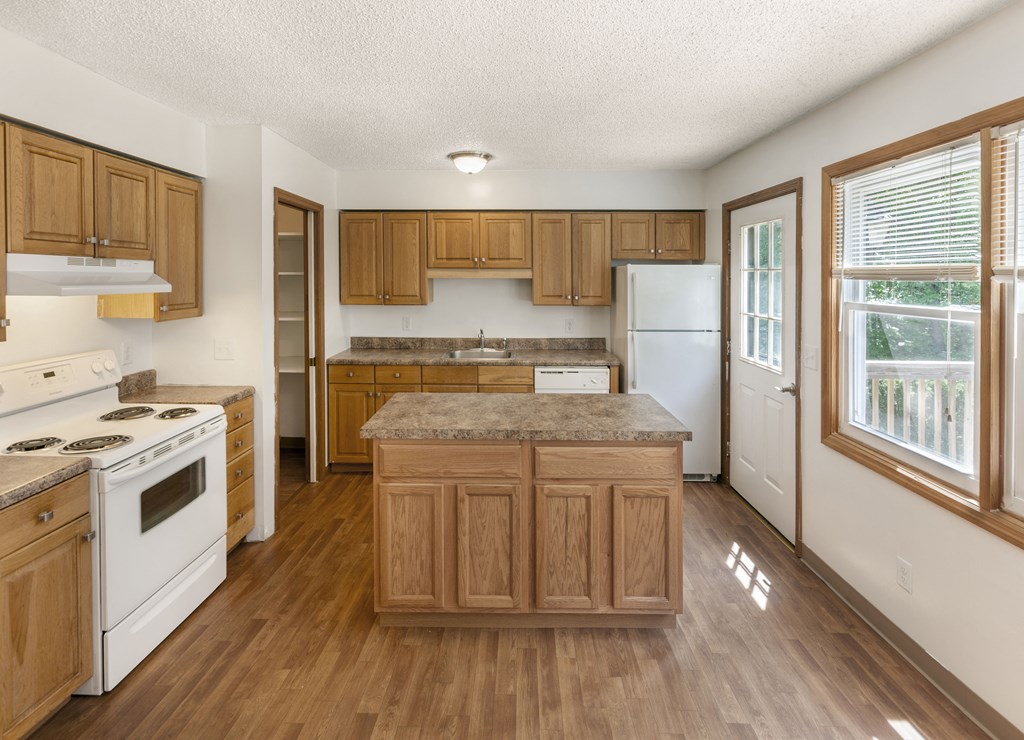 a kitchen with white appliances and wooden cabinets