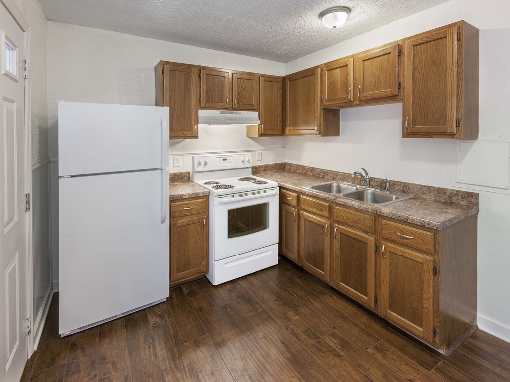 a kitchen with white appliances and wooden cabinets