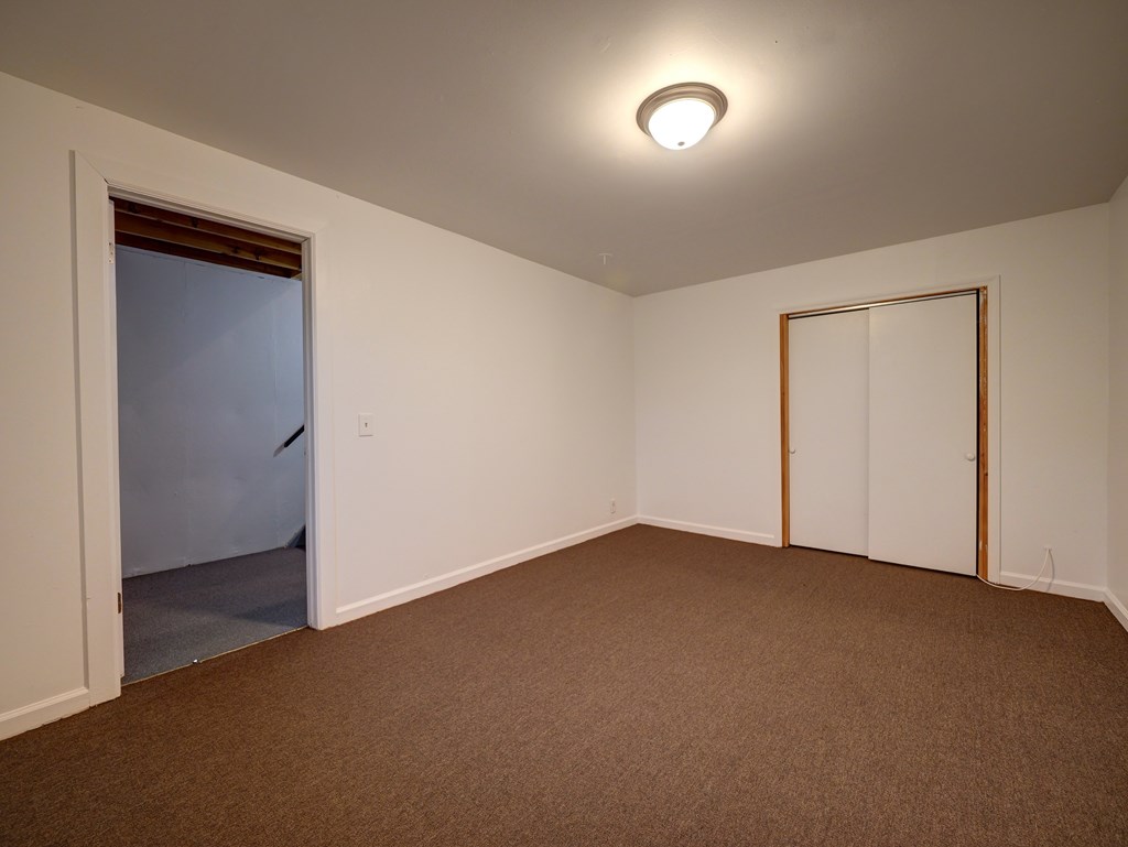 A room with brown carpet and white walls.