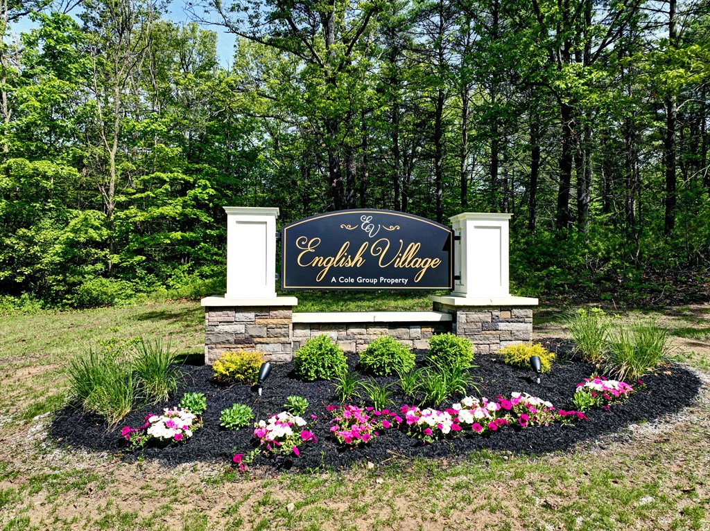 the sign at the end of the subdivision with flowers and plants