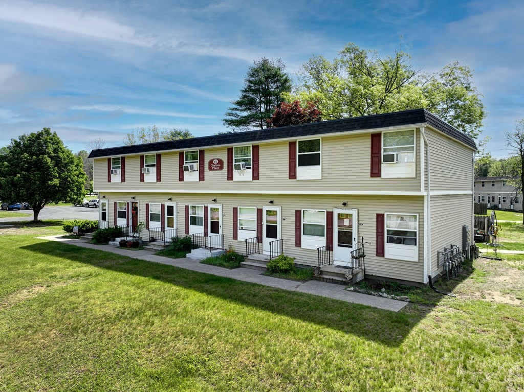 the front of a white house with red shutters and a lawn