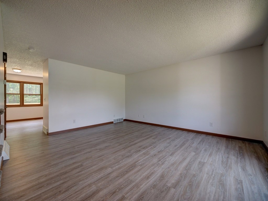 A room with wooden flooring and white walls.
