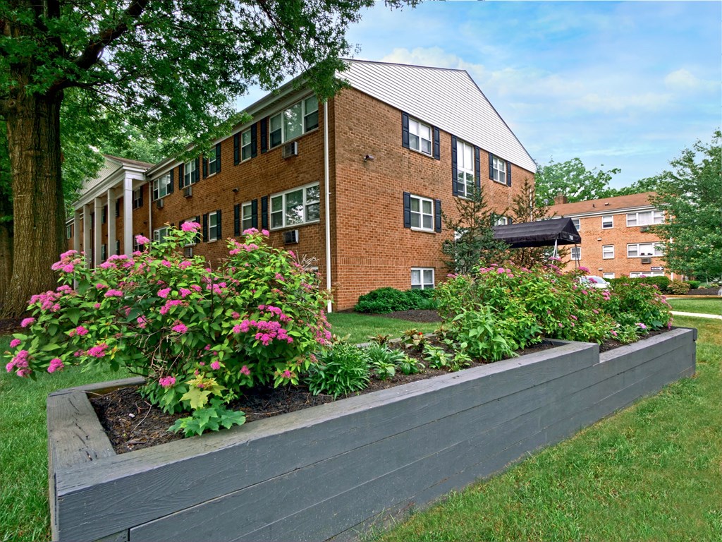 A brick building with a flower bed in front of it.