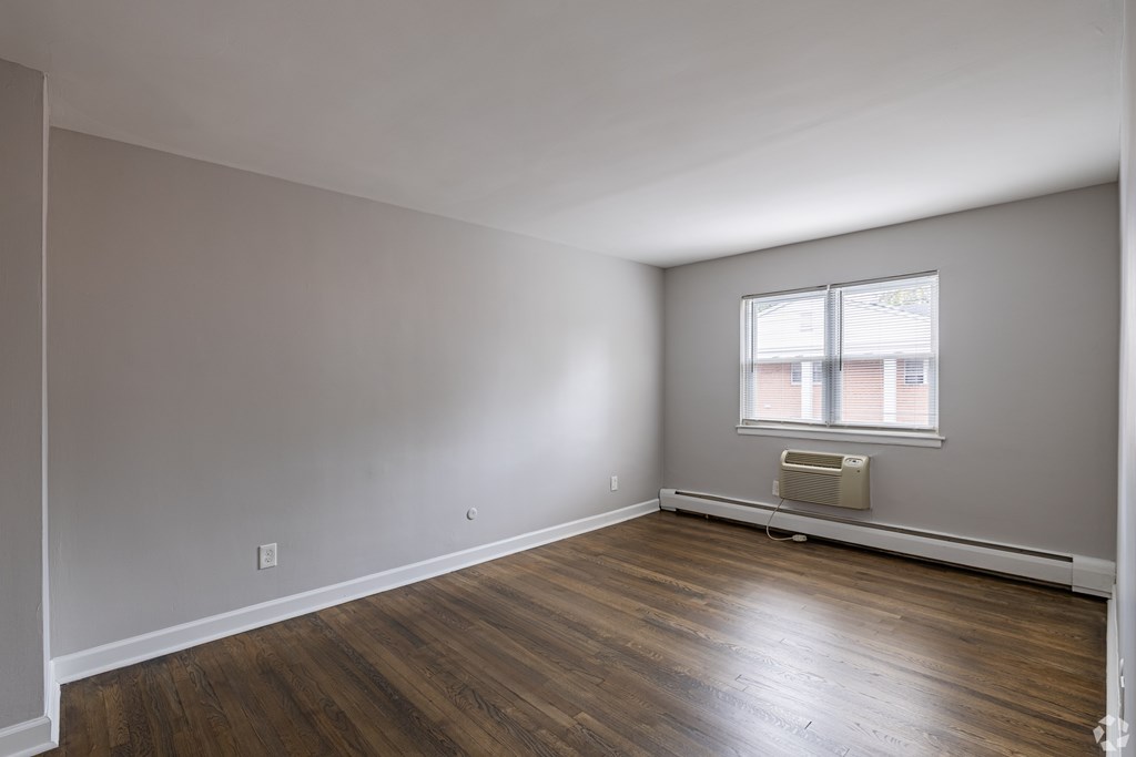 Empty room with wooden floors and a window.