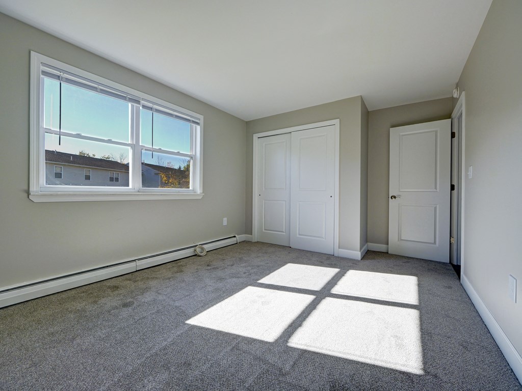 A room with a large window and two doors.
