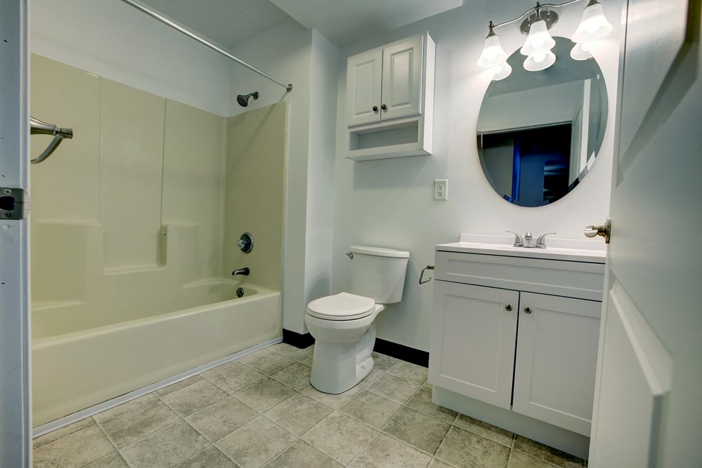 A white bathroom with a toilet, sink, and tub.