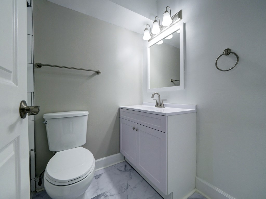 A white toilet and sink in a bathroom.