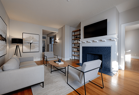 A living room with a grey couch, a coffee table, and a fireplace.