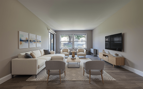 A living room with a white couch, two chairs, and a coffee table.