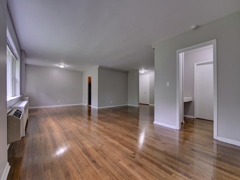 an empty living room with wood floors and grey walls
