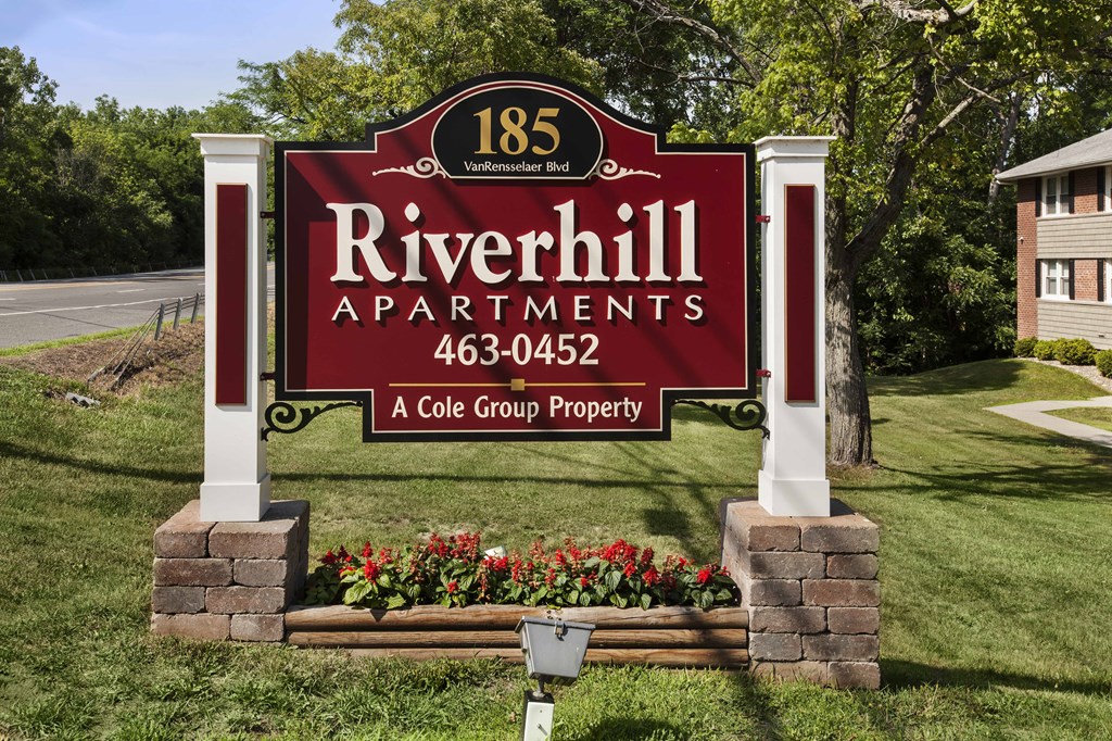 the sign for riverhill apartments on the side of the road