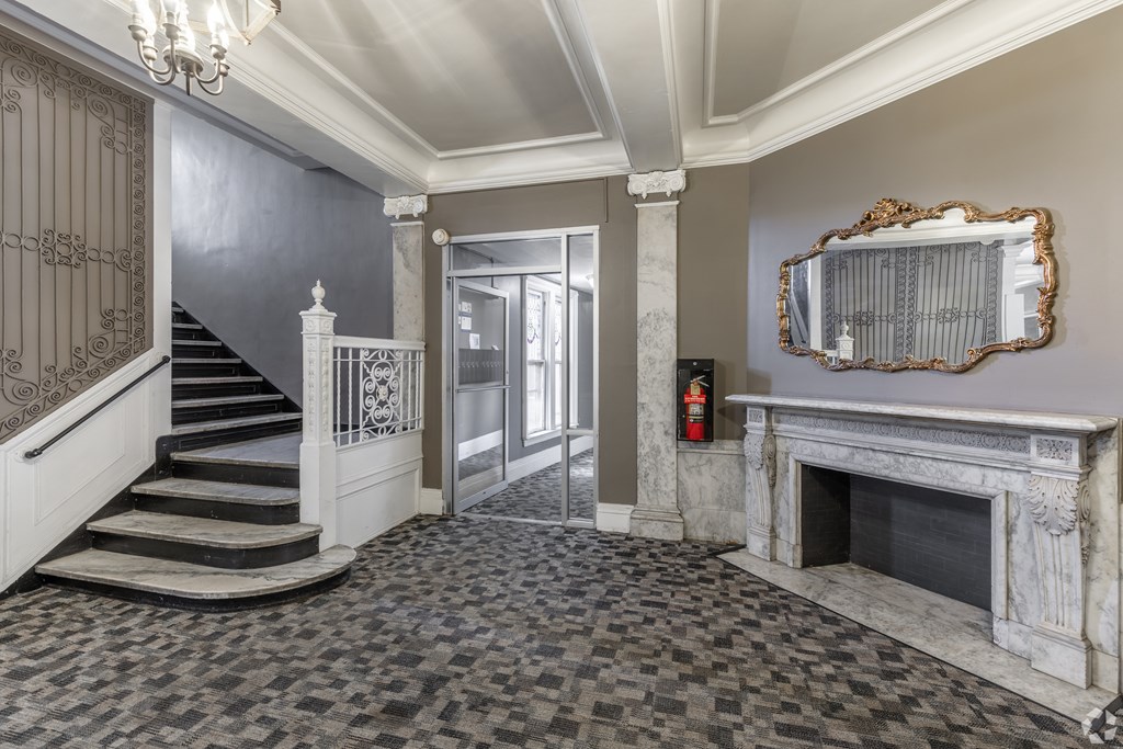 A large room with a fireplace and a mirror on the wall. at Willett Apartments, Albany, NY, 12210