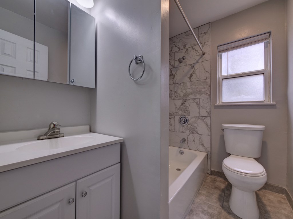 an empty bathroom with a shower toilet and sink