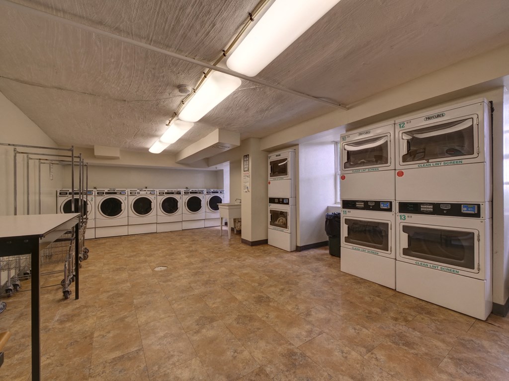 a laundry room with several washers and dryers and a row of washes