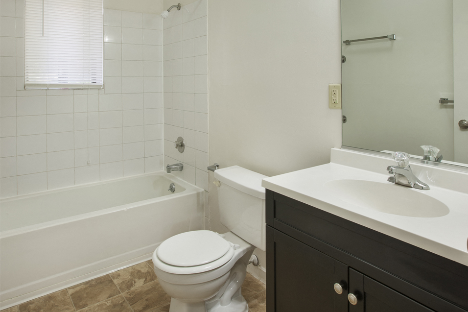 a bathroom with a toilet and a sink and a tub