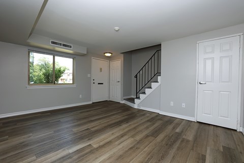 A room with wooden floors and a staircase.