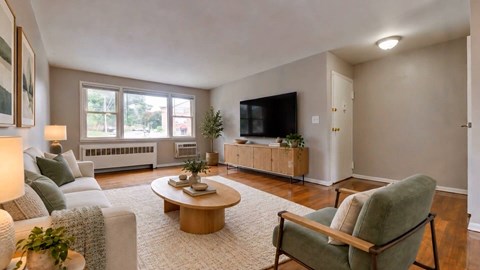 A living room with a grey couch, a green chair, and a coffee table.
