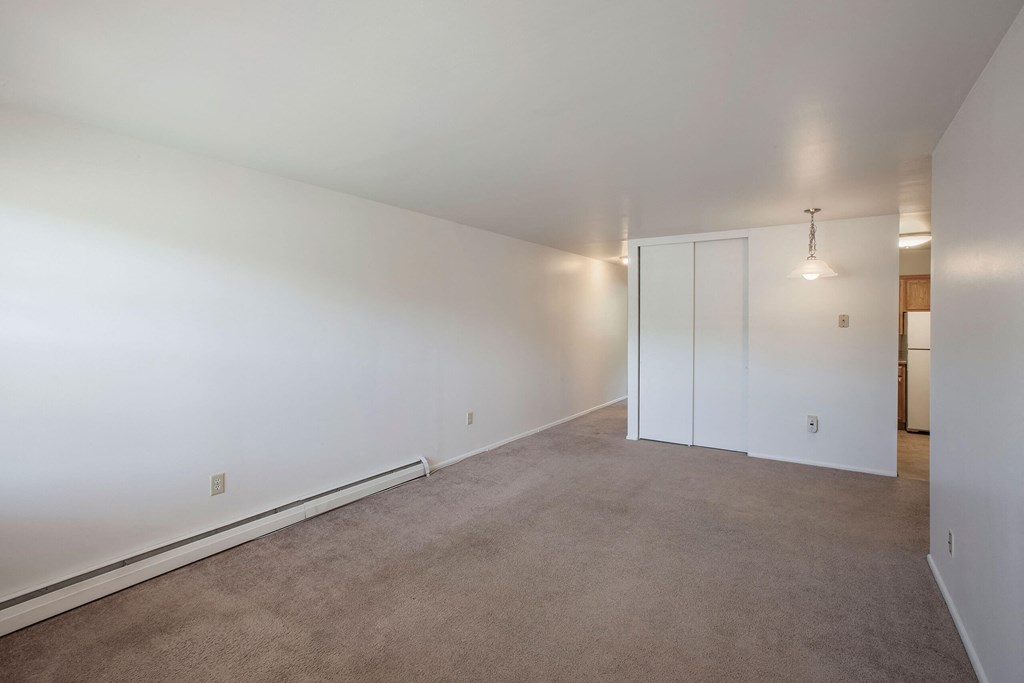 a bedroom with white walls and carpet