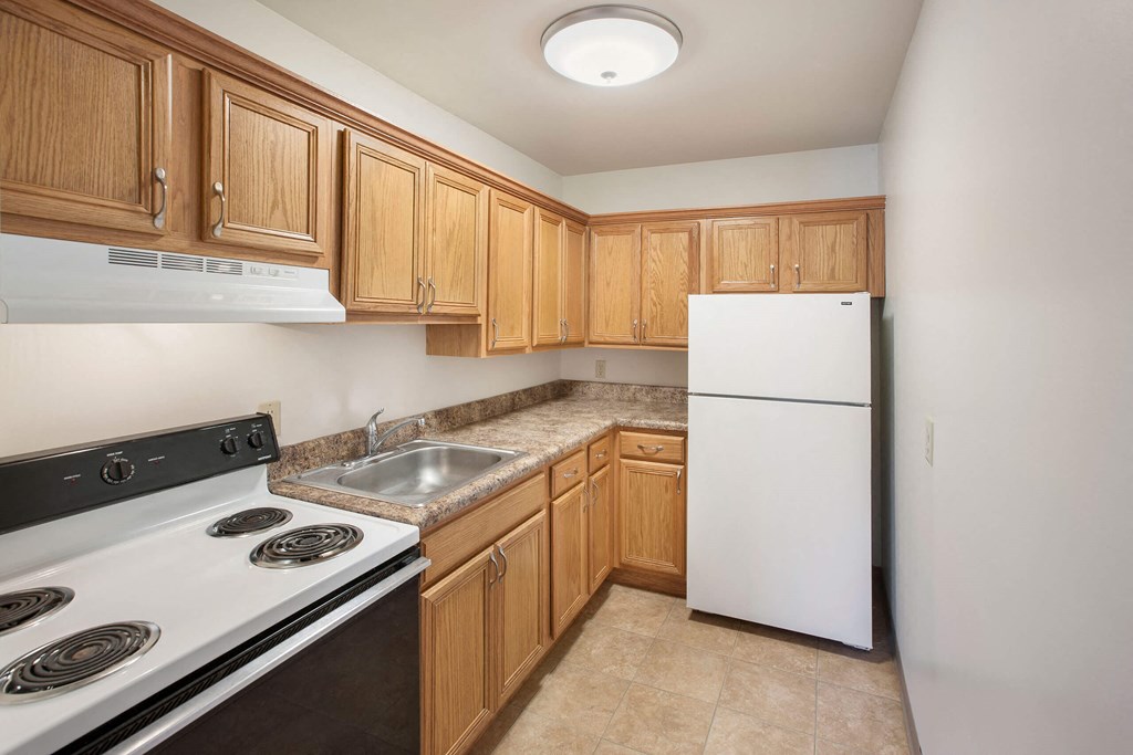 a kitchen with wood cabinets and white appliances
