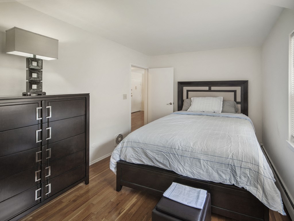 A bedroom with a bed, nightstand, and a lamp.