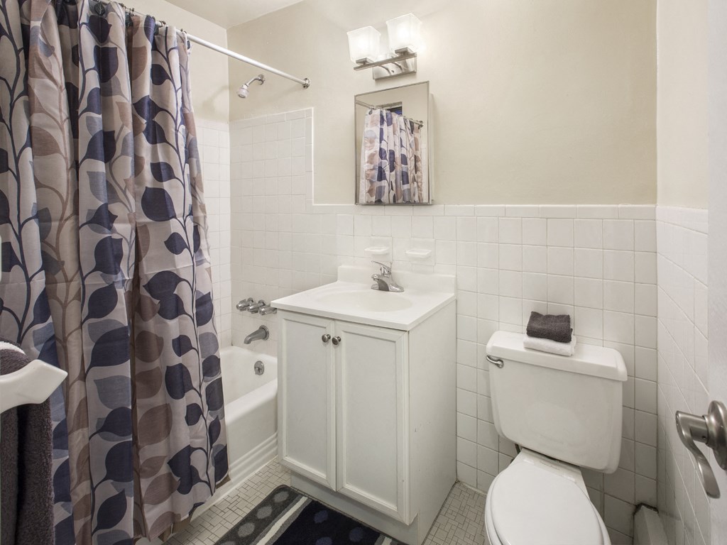 a bathroom with a shower curtain and a toilet and sink