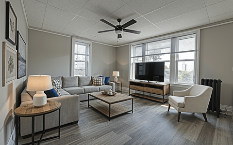 A living room with a grey couch, a coffee table, a television, and a chair.