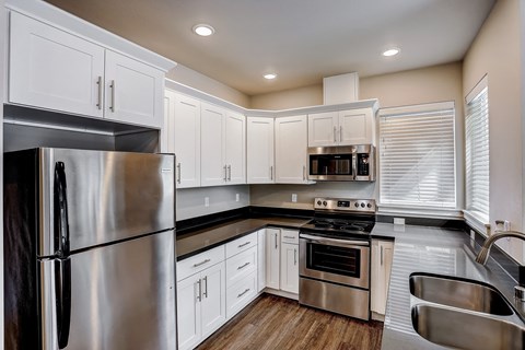 A modern kitchen with stainless steel appliances and white cabinets.