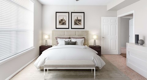 A bedroom with a large bed and two pictures on the wall.