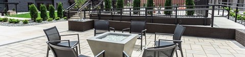 A patio with a table and chairs and a fountain.