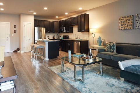 A modern kitchen with black cabinets and a glass table.