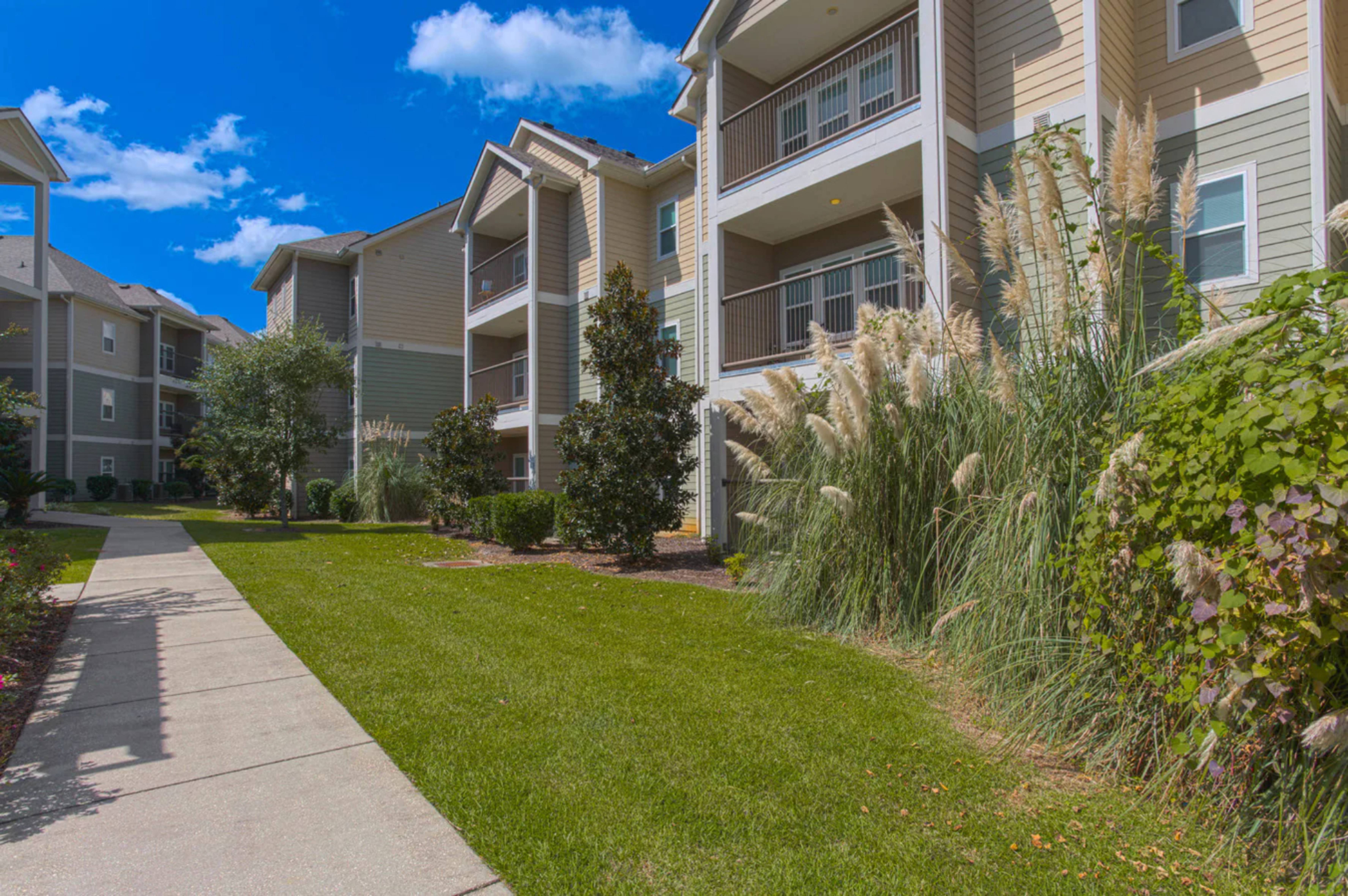 A sunny day at a residential apartment complex with a clear blue sky.