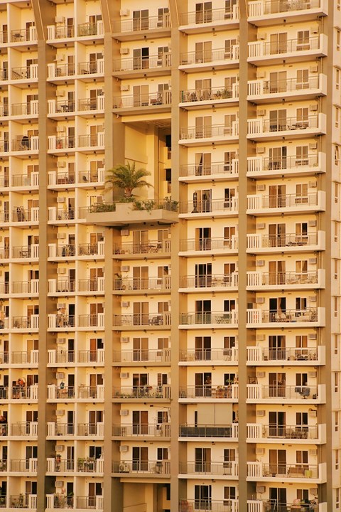 A tall apartment building with balconies and windows.
