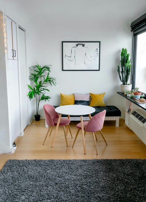 A dining room with a white table and chairs.