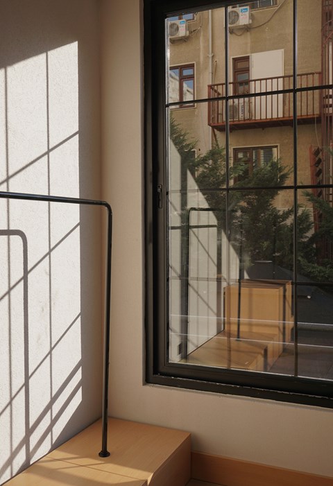 A window with a view of a balcony and a building outside.