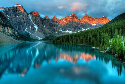 A serene landscape with a lake reflecting the mountains and trees.