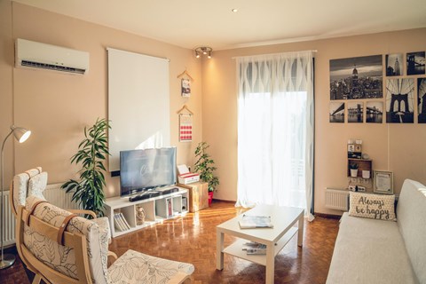 A living room with a television, a couch, and a chair.