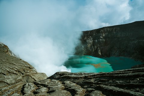 A turquoise pool of water is surrounded by rocky cliffs.