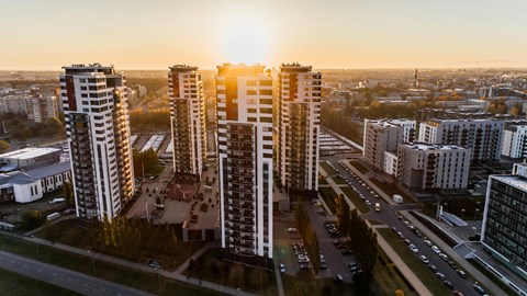 A sunset view of a cityscape with tall buildings and a highway.