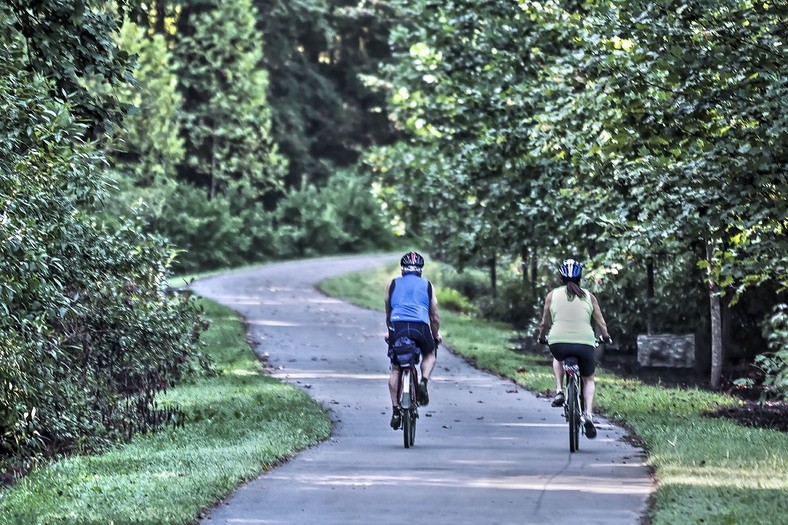 a man and a woman riding bikes down a road