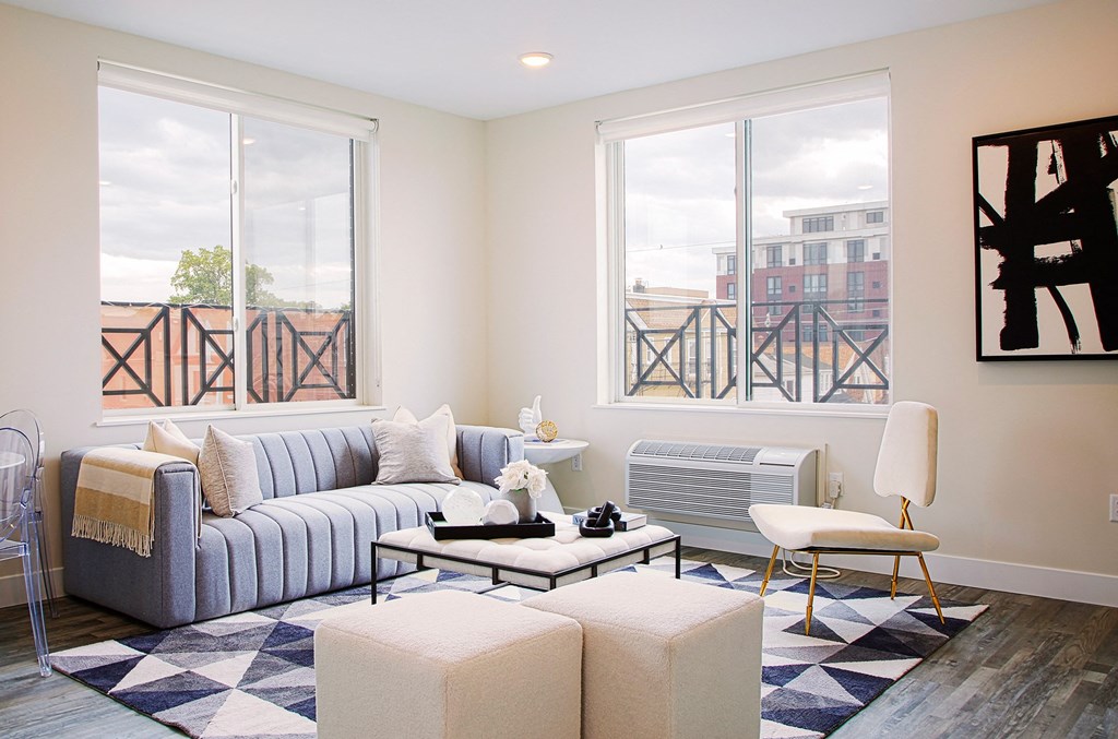 a living room with a blue and white checkered rug and a gray couch