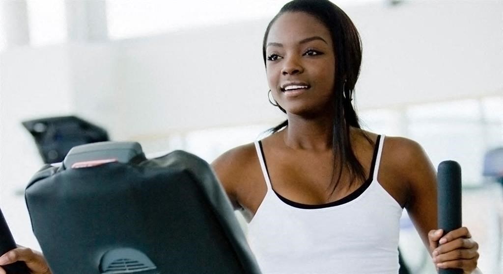 a woman is walking on a treadmill at the gym