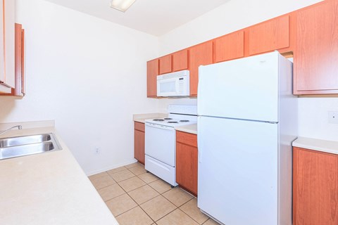 A kitchen with white appliances and wooden cabinets.