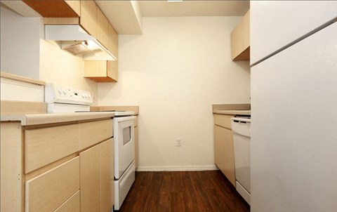 A kitchen with white appliances and wooden cabinets.