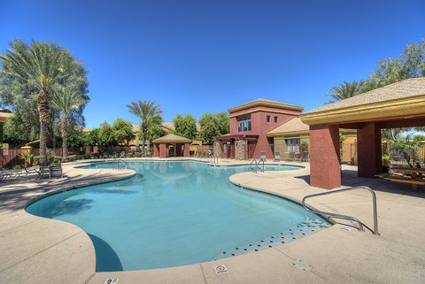 A large swimming pool with a building in the background.