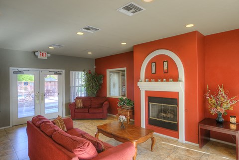 A living room with a red couch and a fireplace.
