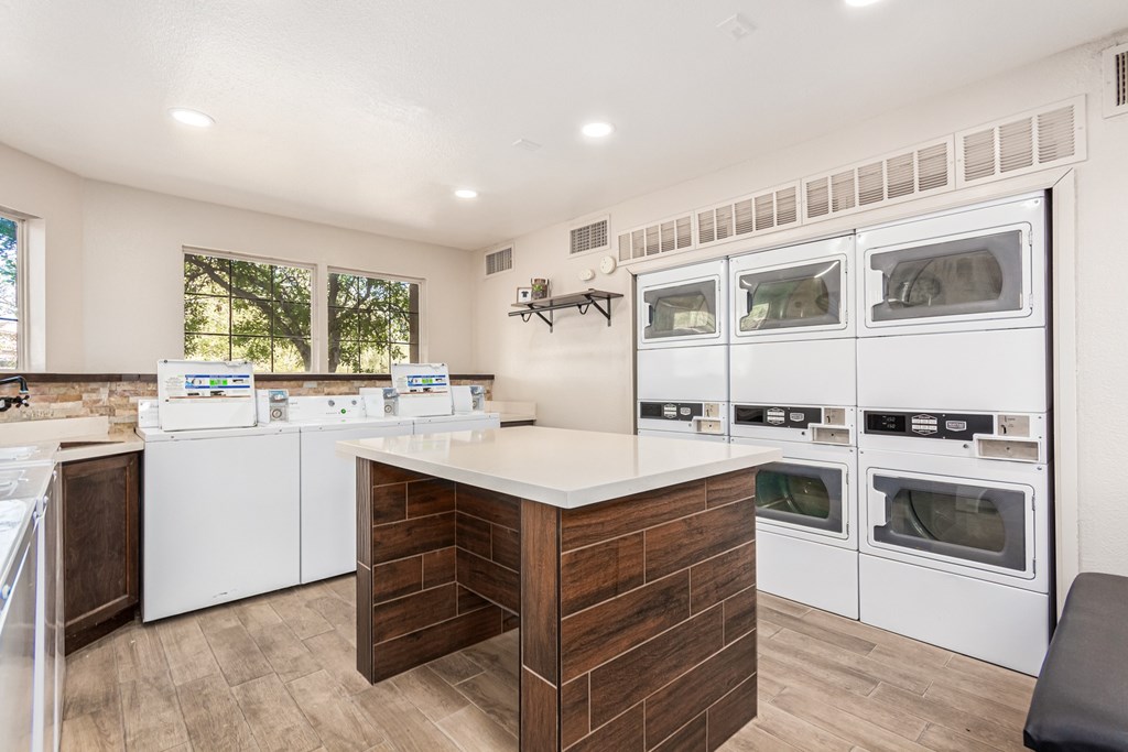 A kitchen with white appliances and a wooden island.